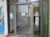 einflügelige Glastür mit einer senkrechten Griffstange, Türrahmen Metall, in Glasfront eingelassen