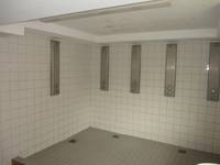 gekachelter Raum mit fünf Duschplätzen
