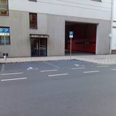 Parkplatz zwischen 2 anderen Stellplätzen. Großes Rollstuhlsymbol  auf dem Boden
